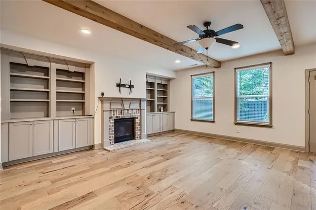 a view of an empty room with a fireplace and a window