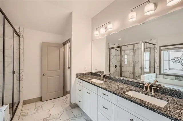 a bathroom with a granite countertop double vanity sink and a mirror