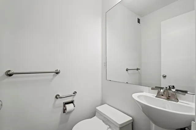a bathroom with a sink mirror and toilet