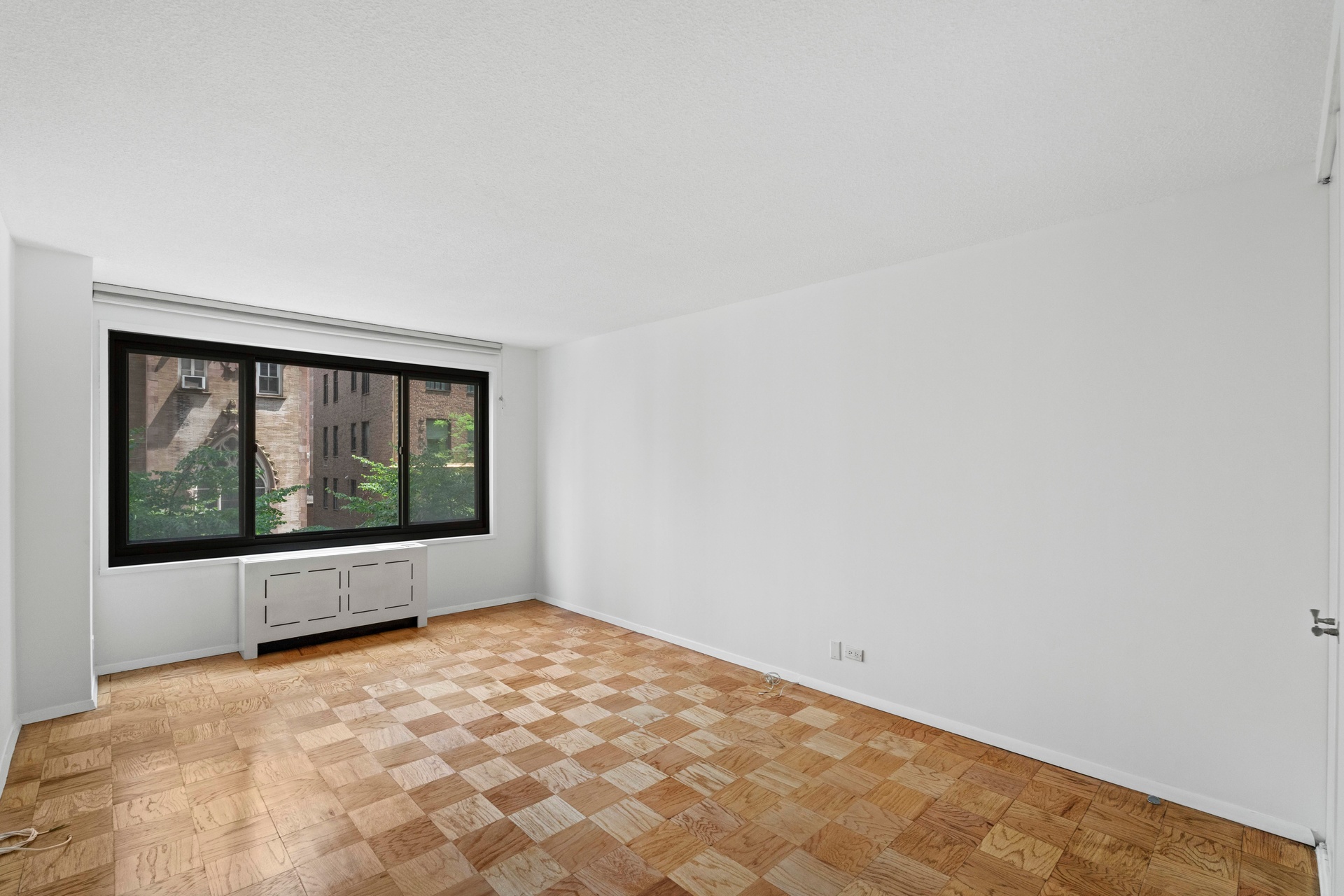 50 East 89th Street, Unit 3C Manhattan, NY 10128 - Photo 6 of 16 a view of empty room with wooden floor and fan