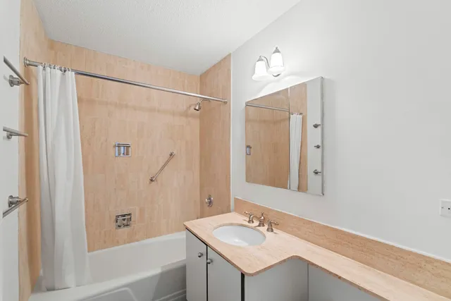 a bathroom with a sink tub shower and a mirror
