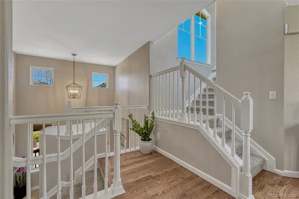 a view of staircase with railing and white walls