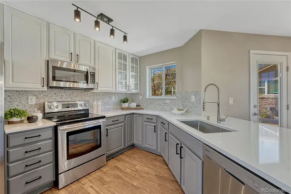 a kitchen with stainless steel appliances granite countertop a sink and stove top oven