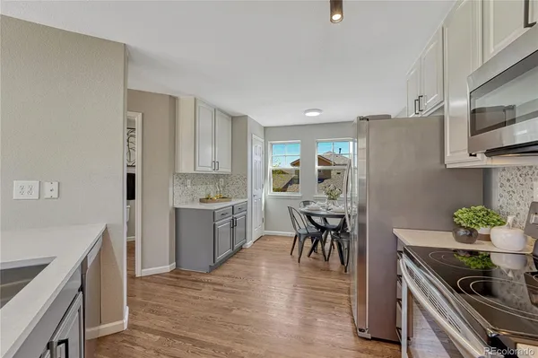a kitchen with granite countertop a refrigerator stove top oven and sink