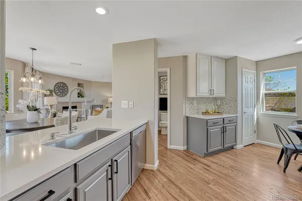 a kitchen with a sink cabinets and wooden floor