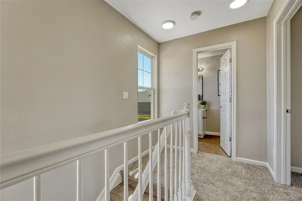 a view of a hallway with a livingroom and front door