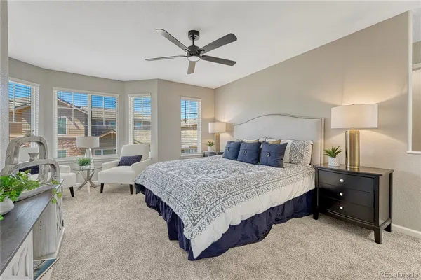 a spacious bedroom with a bed and ceiling fan