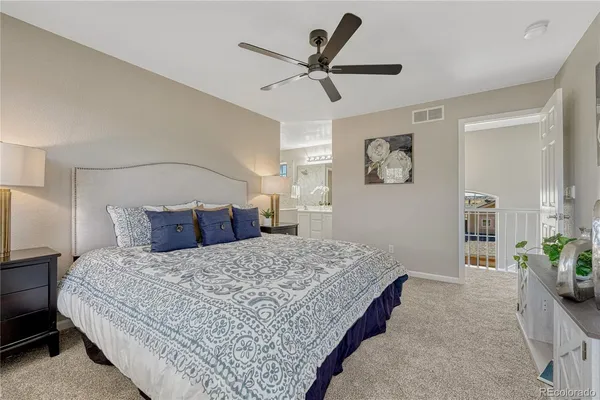 a bed room with a bed and a ceiling fan