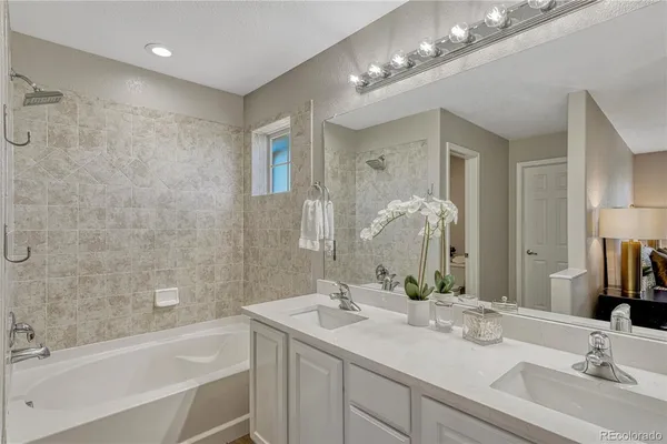 a bathroom with a sink double vanity granite tub and a mirror