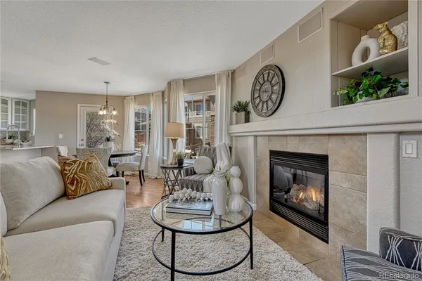 a living room with furniture a clock and a fireplace