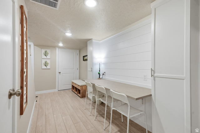 3244 West 1670th Street North Provo, UT 84601 - Photo 40 of 56 Recessed lighting illuminating a spacious room featuring light wood-finish flooring, a built-in desk surface, and white shiplap accent wall