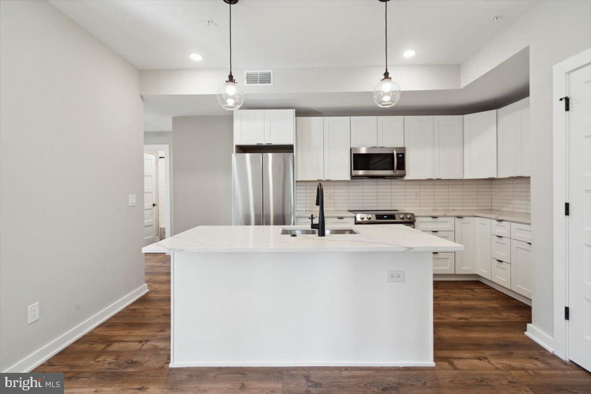 3801 Hamilton Street, Unit B Philadelphia, PA 19104 - Photo 27 of 46 a kitchen with stainless steel appliances a stove top oven a refrigerator and cabinets