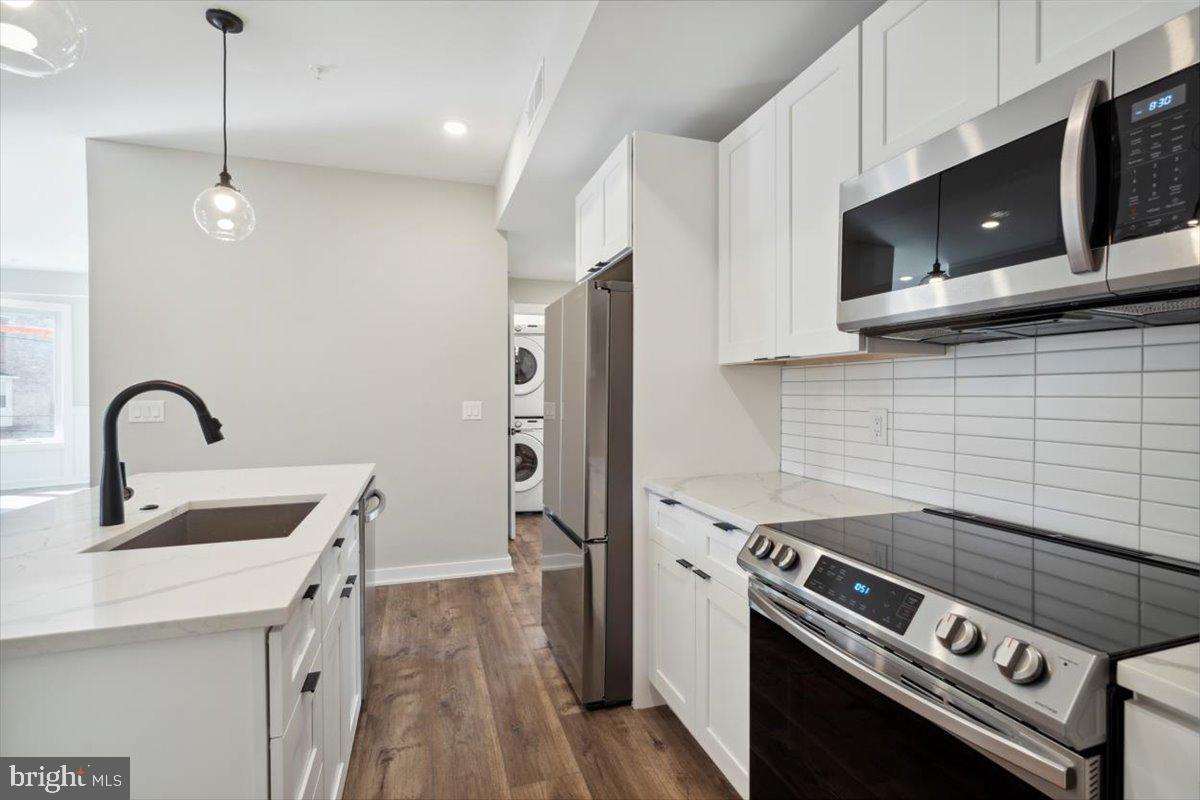 3801 Hamilton Street, Unit B Philadelphia, PA 19104 - Photo 29 of 46 a kitchen with stainless steel appliances granite countertop a stove a sink and a microwave