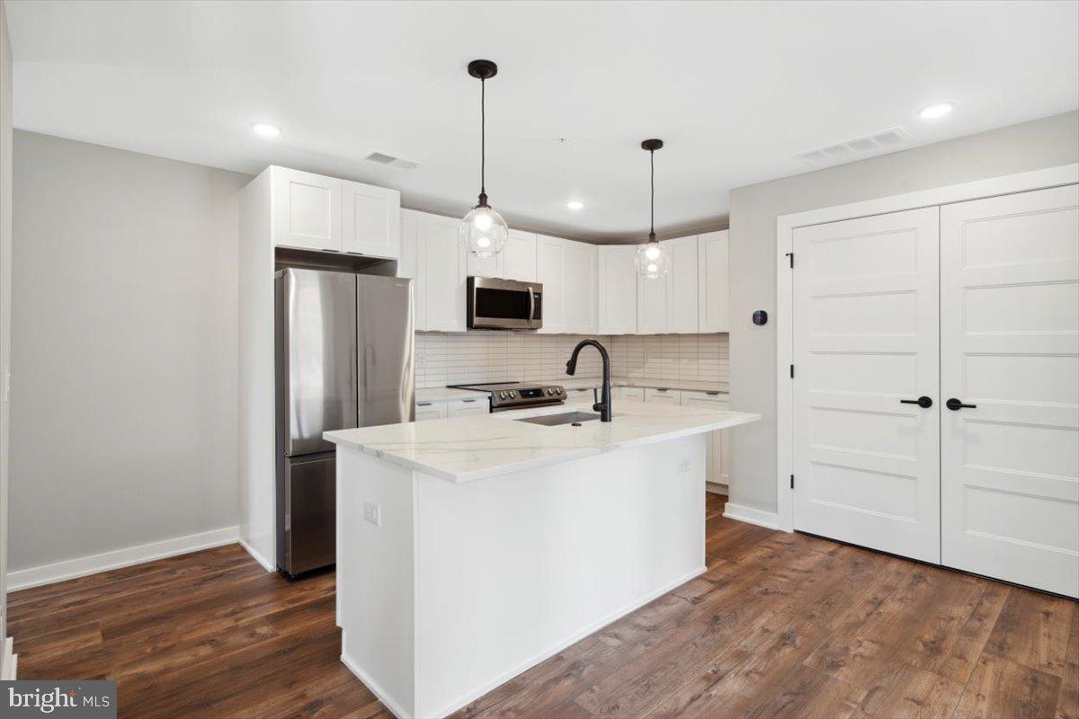 3801 Hamilton Street, Unit B Philadelphia, PA 19104 - Photo 38 of 46 a kitchen with kitchen island a sink stainless steel appliances and wooden floor