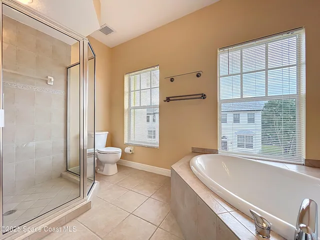 a spacious bathroom with a granite countertop toilet a sink and a large mirror