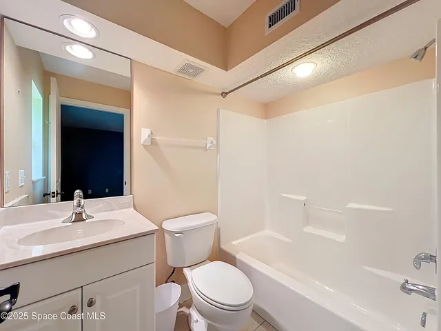 a bathroom with a sink a toilet a mirror and shower