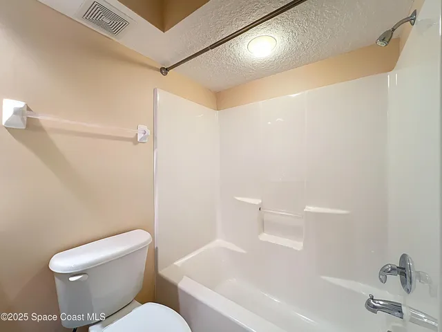 a white toilet sitting next to a bath tub