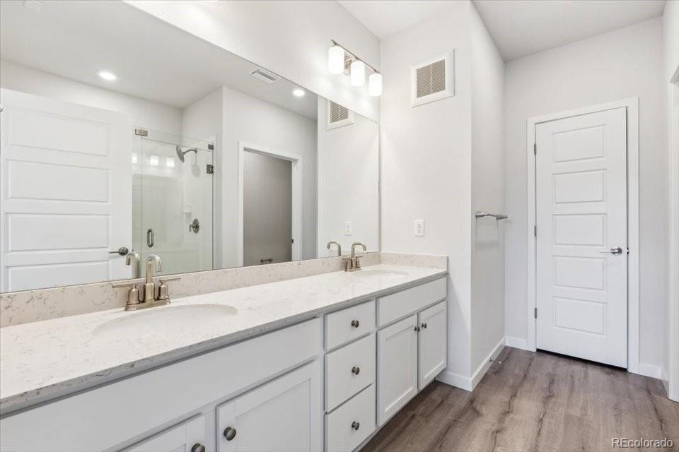 485 Interlocken Boulevard, Unit 209 Broomfield, CO 80021 - Photo 14 of 15 a bathroom with a double vanity sink a mirror and a shower