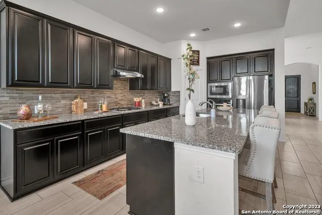 a kitchen with stainless steel appliances granite countertop a sink stove and refrigerator