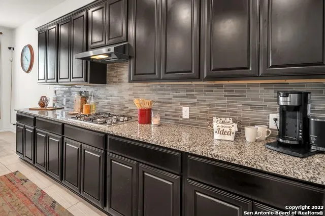 a kitchen with granite countertop stainless steel appliances a sink and cabinets