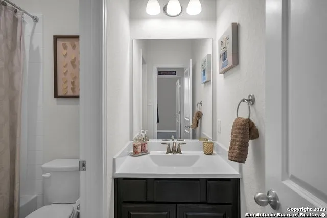 a bathroom with a sink vanity and a toilet