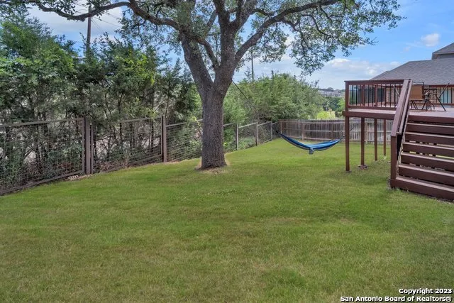 a view of a house with backyard and a tree