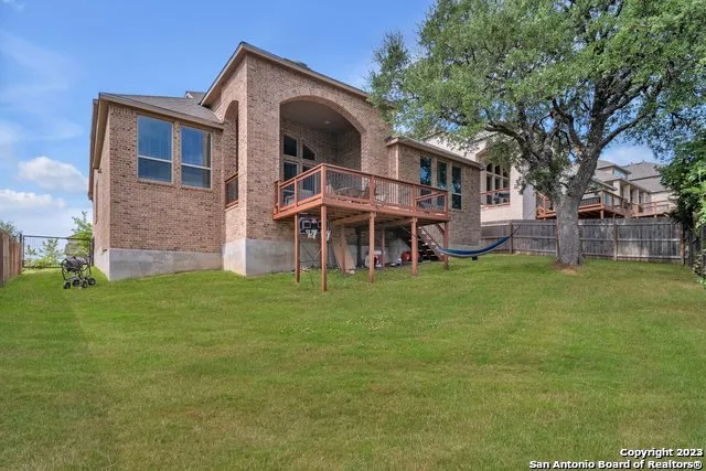 a view of a big house with a big yard and large trees