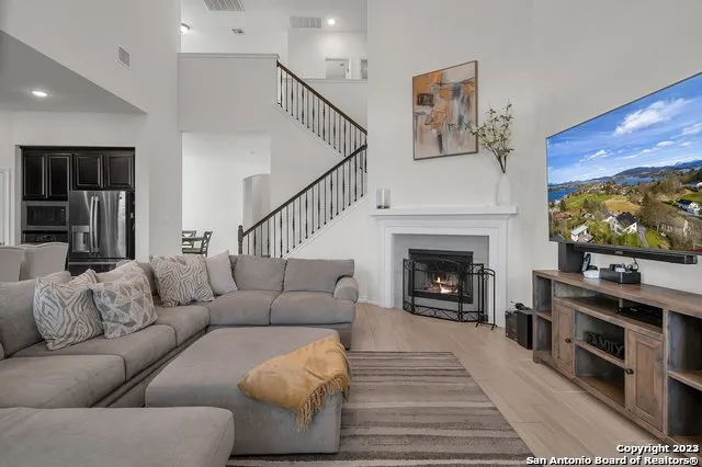 a living room with furniture a flat screen tv and a fireplace