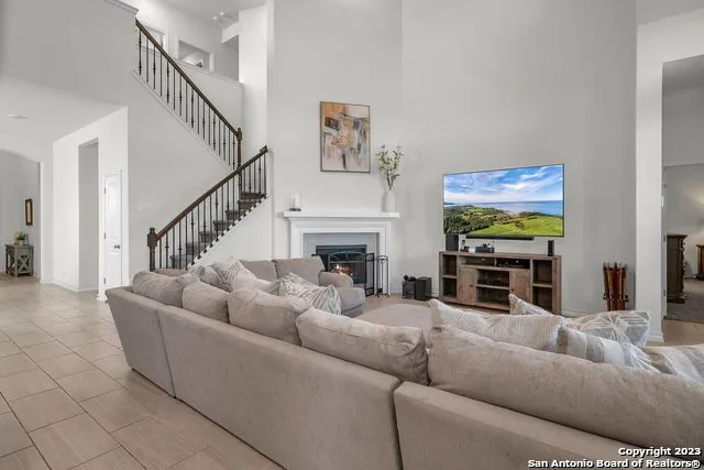 a living room with furniture a fireplace and a flat screen tv
