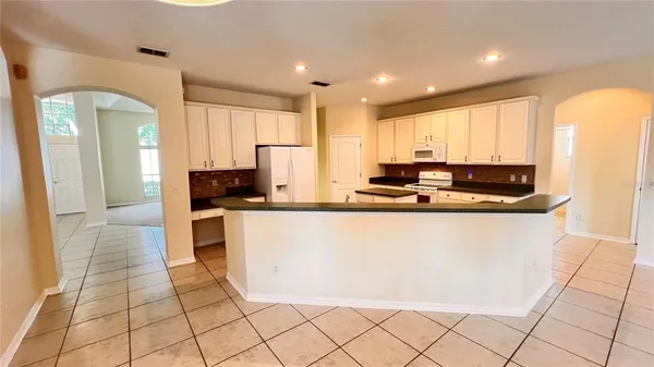 a kitchen with stainless steel appliances granite countertop a sink a stove and a refrigerator