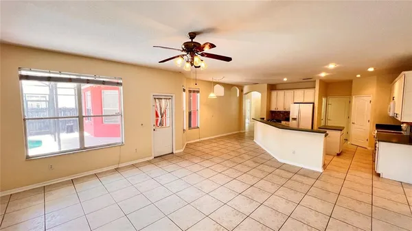 a view of empty room with window and ceiling fan