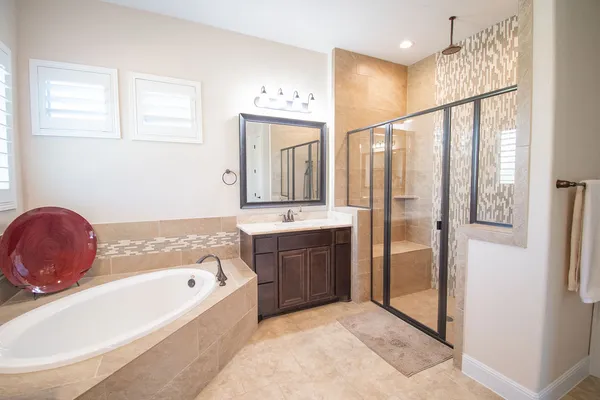 a bathroom with a tub a sink and a mirror
