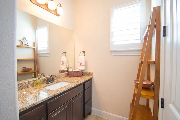 a bathroom with a granite countertop sink and a mirror