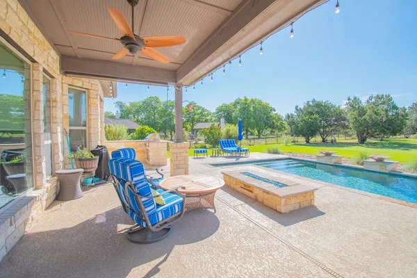 a swimming pool with outdoor seating and yard