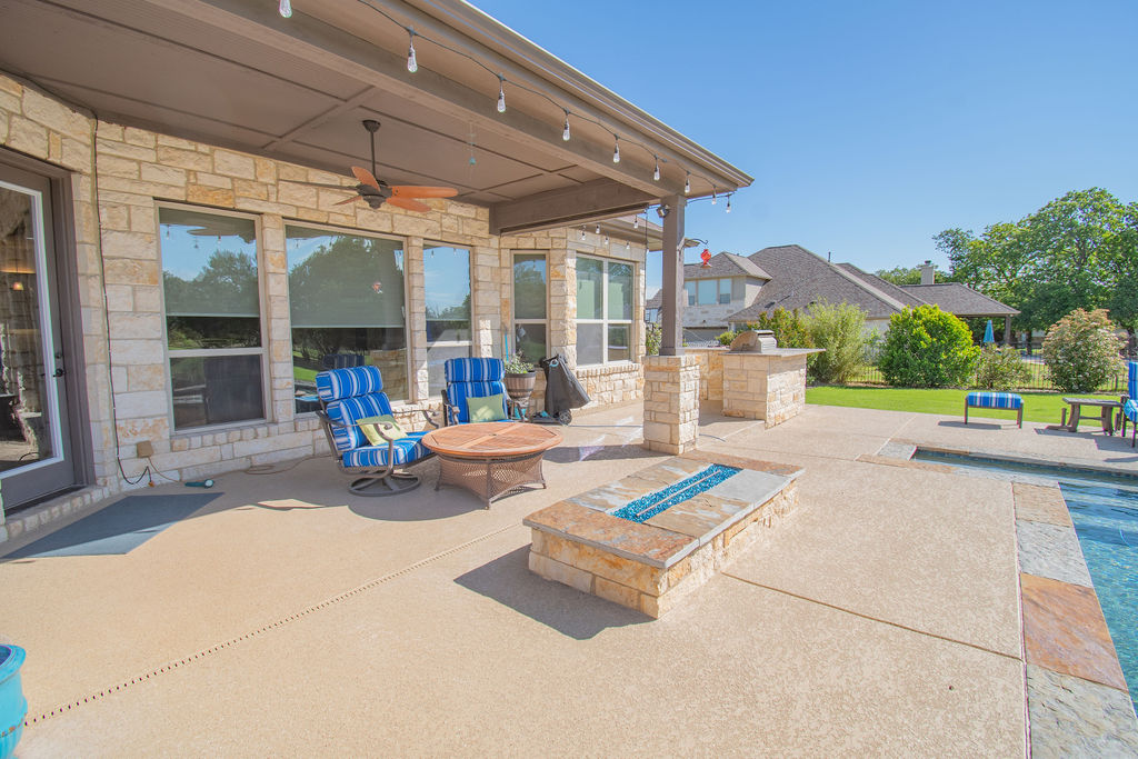 Undisclosed Address Georgetown, TX 78633 - Photo 29 of 39 a view of a patio with a table and chairs under an umbrella with a small yard