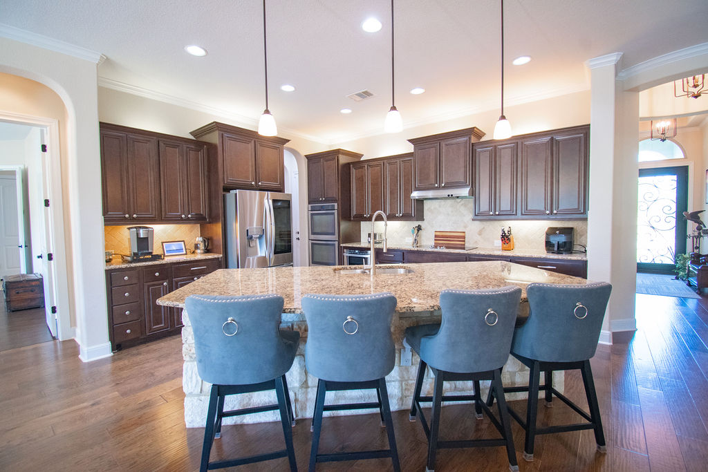 Undisclosed Address Georgetown, TX 78633 - Photo 5 of 39 a kitchen with stainless steel appliances granite countertop a dining table chairs refrigerator and microwave