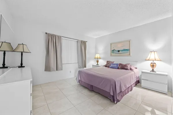 a spacious bedroom with a bed and a lamp