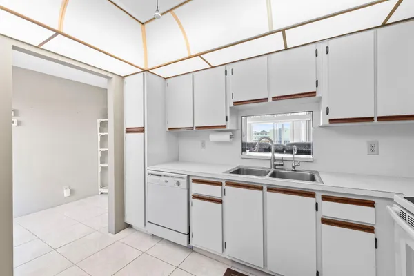 a kitchen with white cabinets and white appliances