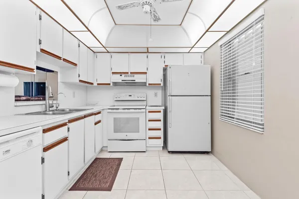 a kitchen with white cabinets and white appliances