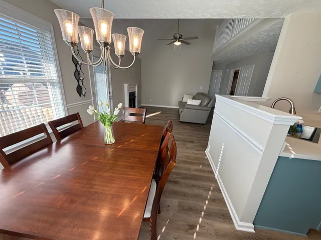 a dining room with furniture and a wooden floor
