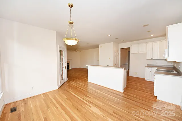 a large kitchen with cabinets and wooden floor