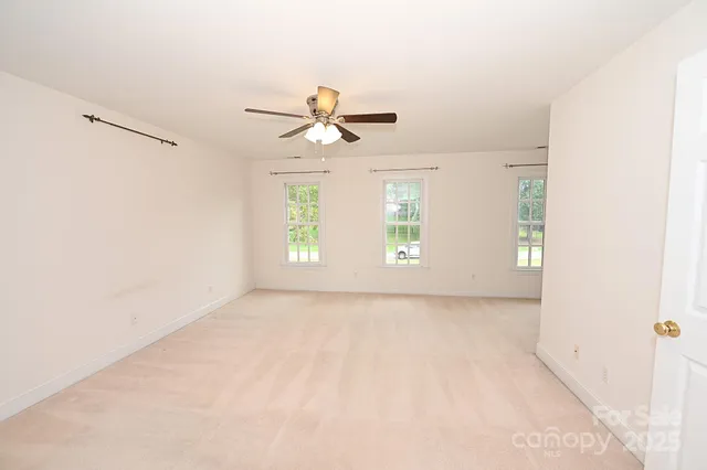 a view of a room with a ceiling fan and a window