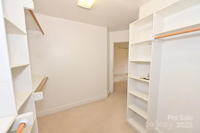a view of walk in closet with empty racks