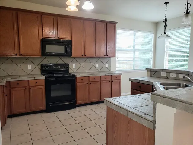 a kitchen with a stove sink and cabinets