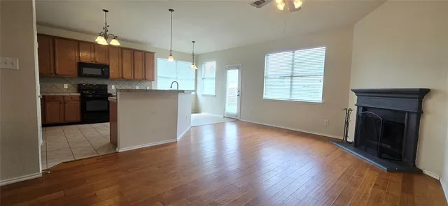 a kitchen with granite countertop wooden floors and wide window
