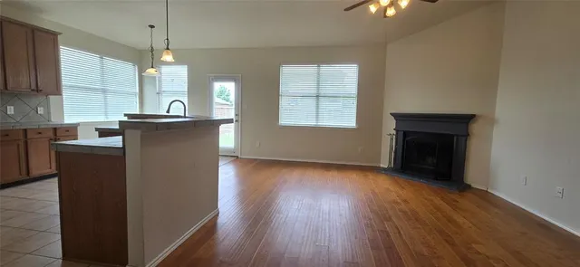 a kitchen with kitchen island wooden floors appliances and cabinets