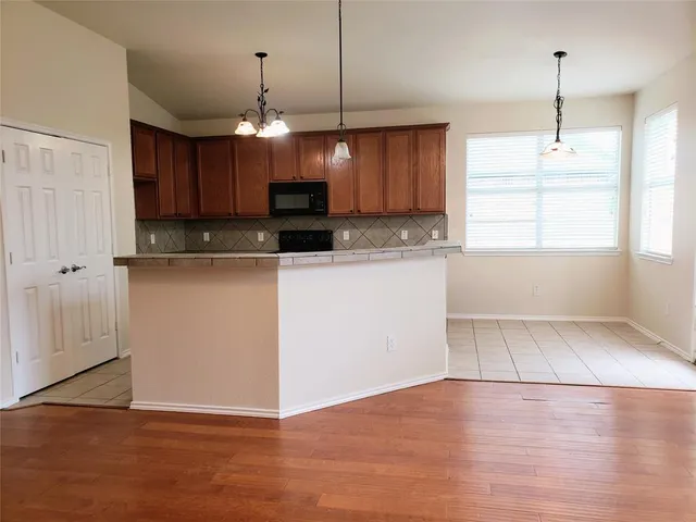 a view of a kitchen with a sink microwave and cabinets