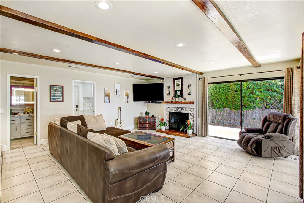9111 Hidden Farm Road Alta Loma, CA 91737 - Photo 16 of 45 a living room with furniture a fireplace and a flat screen tv