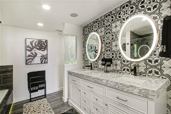 a bathroom with a granite countertop sink and a mirror