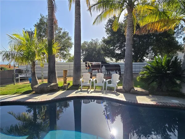 a view of a balcony with chairs and wooden fence